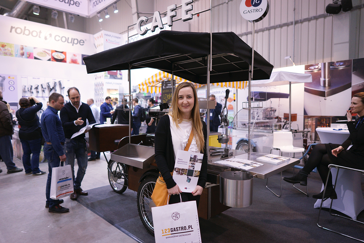 Euro Gastro czas zacząć, w ręku niezbędnik zwiedzającego – duża torba na ulotki reklamowe, wizytówki, próbki i miejmy nadzieję – dużo kawy w ziarenkach.